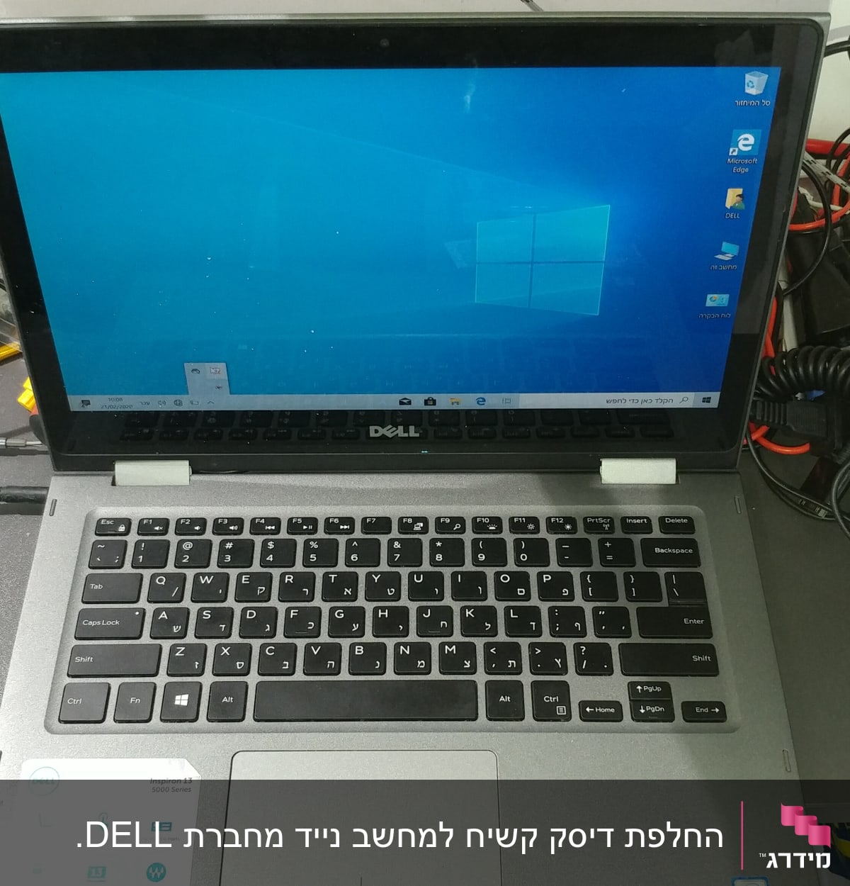 מחשב נייד דל על שולחן עם כבלים וכלים